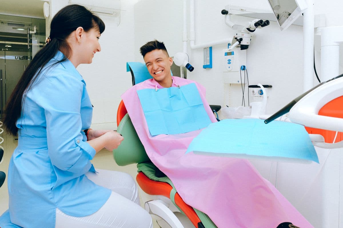 painless root canal CBD Belapur — relaxed patient consulting with dentist