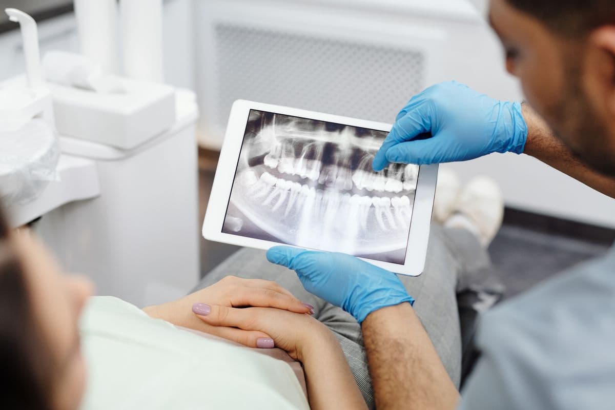 root canal retreatment CBD Belapur dentist reviewing dental x-ray with patient