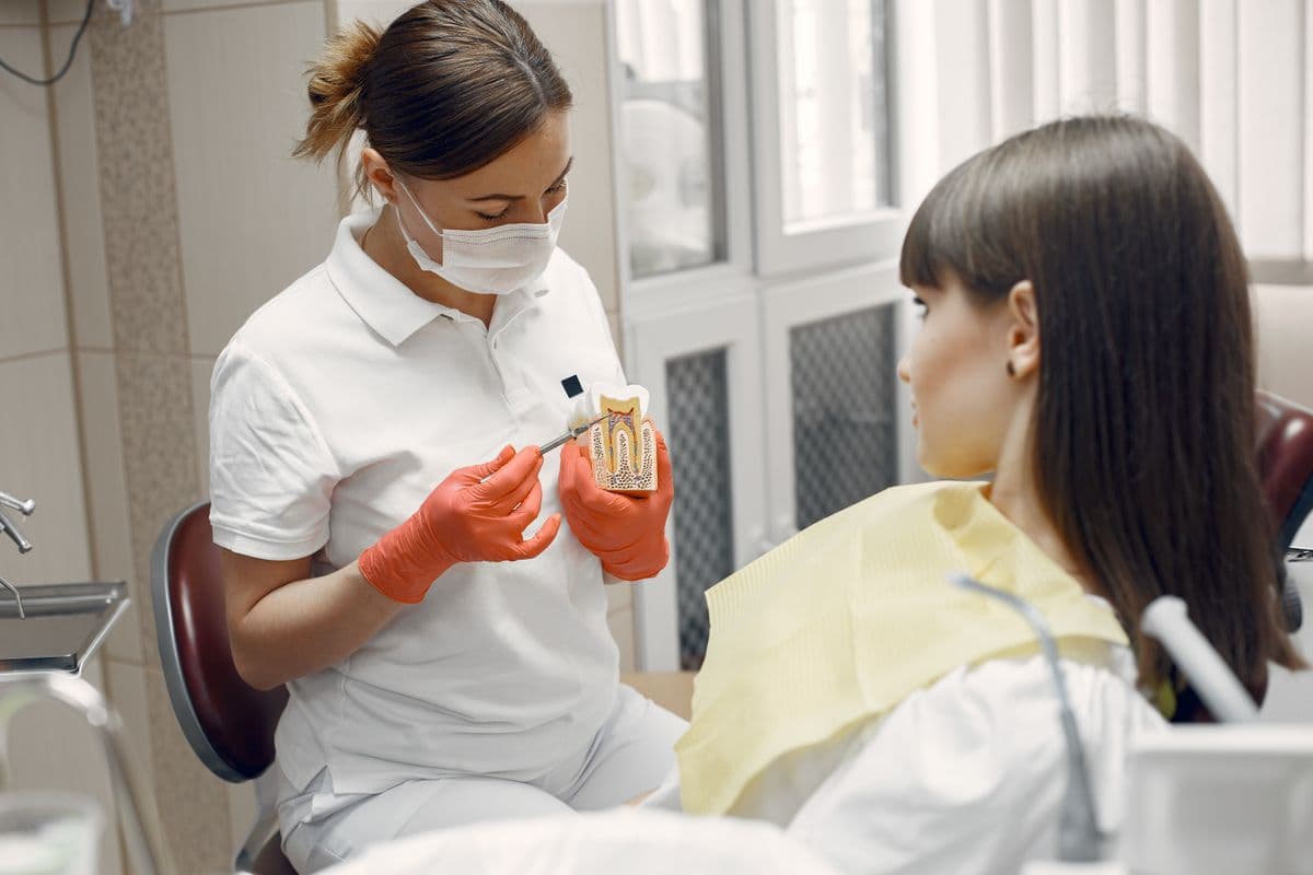 dental crown Belapur — dentist discussing tooth model with patient at CBD Belapur clinic